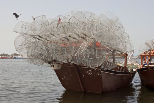 A traditional fishng dhow loaded with gargours (fish traps), Sharjah, United Arab Emirates.