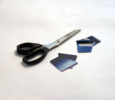 Two cut credit cards and pair of black scissors