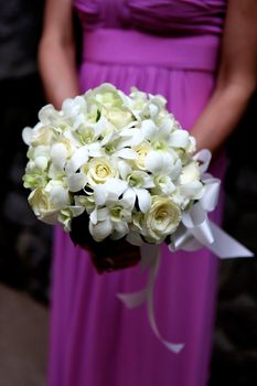 Close-up of a bridesmaid holding a beautiful bouquet.