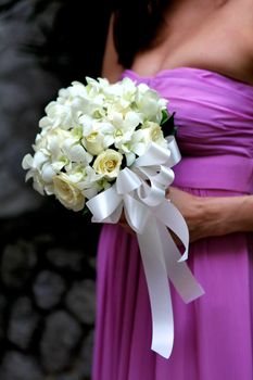 Close-up of a bridesmaid holding a beautiful bouquet.