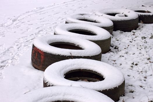 Fragment of the row old tires. Serve on the side limiter training track. Winter season