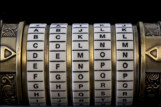 demon word set up as a password to combination puzzle box (cryptex) with rings of letters; black background