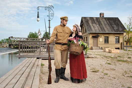 Couple of lady and soldier shown on retro-style picture. Costumes accord the times of World War I. Photo made at cinema city Cinevilla in Latvia.
