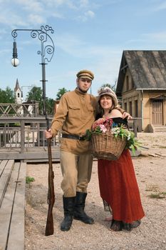 Couple of lady and soldier shown on retro-style picture. Costumes accord the times of World War I. Photo made at cinema city Cinevilla in Latvia.

