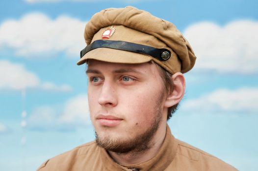 Portrait of soldier in uniform of World War 1 on the background of blue sky. Costume accord the times of World War I. Photo made at cinema city Cinevilla in Latvia. Cockade on the hat do not contain trade mark.