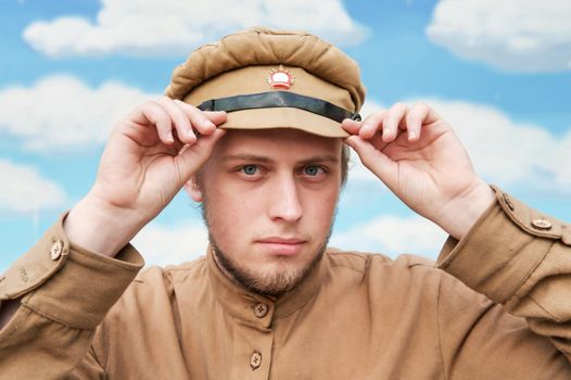 Portrait of soldier in uniform of World War 1 on the background of blue sky. Costume accord the times of World War I. Photo made at cinema city Cinevilla in Latvia. Cockade on the hat do not contain trade mark.