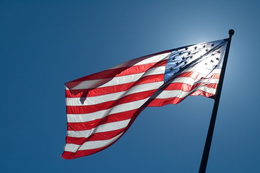 back lighted american flag, clear blue sky