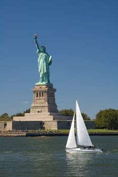 statue of liberty and white yacht, clear blue flag