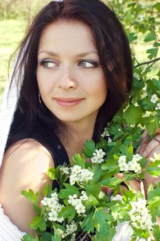 Beautiful woman in white near blooming tree