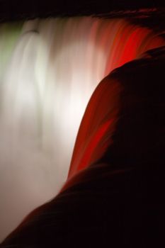 detail abstract photo of niagara falls at night, lighted with red color 
