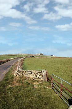 quiet road with a derelict house in the irish countryside in county kerry ireland