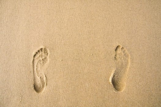 two human footprints in sand, brown color
