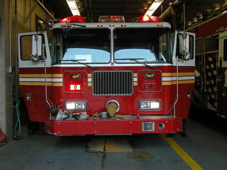 front view of a red firetruck in a fire station