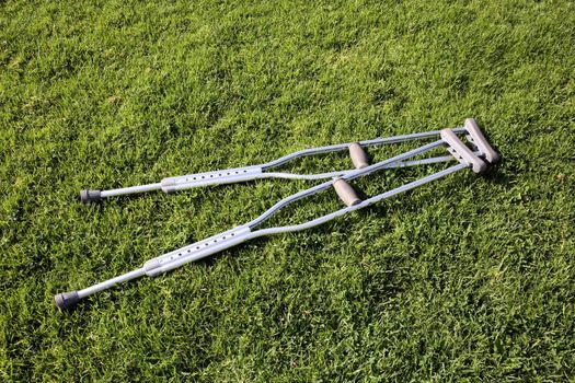 A pair of crutches laying on green grass