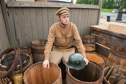 Soldier with a helmet sitting on the butt.
Costume accord the times of World War I. Photo made at cinema city Cinevilla in Latvia.