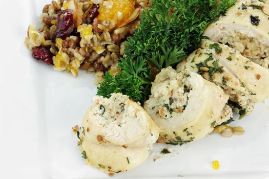 Chicken Roulade stuffed with spinach and almond paste served with pilaf with whole grains, nuts, and dried fruit.