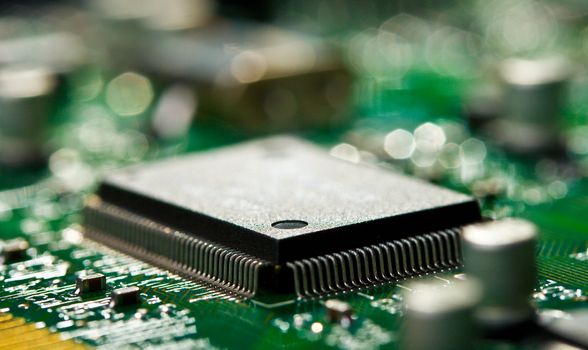 close-up chip on green circuit board with selective focus