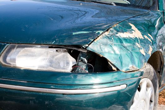 close-up damaged green car