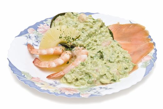 Avocado salad decorated with prawns, a slice of pineapple and a slice of salmon.