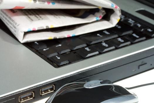 close-up laptop mouse and newspaper