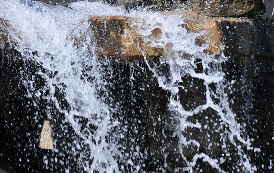 water splashing over rocks an flowing into a pool below