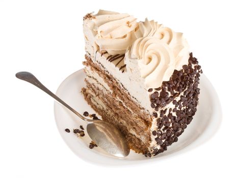 close-up piece of cake on white plate with spoon, isolated