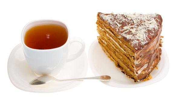 tea cup and piece of home made honey cake, isolated on white