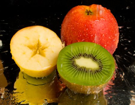 water spray on kiwi and apples, on black