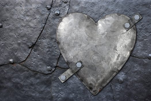 Photo of a galvanized metal heart bolted to old hammered metal plates with rivets.
