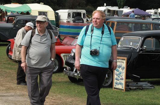 two men enjoying themselves at a vintage car rally