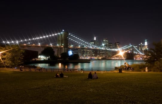 Brooklyn bridge and lower manhattan at night, photo taken from a park in brooklyn