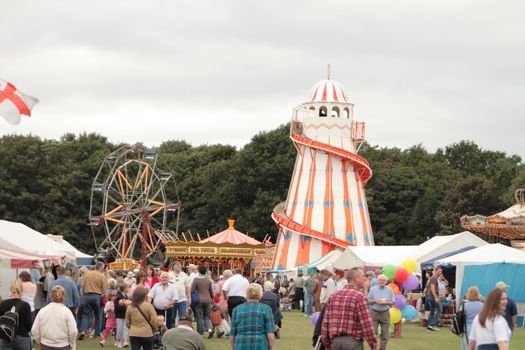 fair ground rides and tents with a good show of people