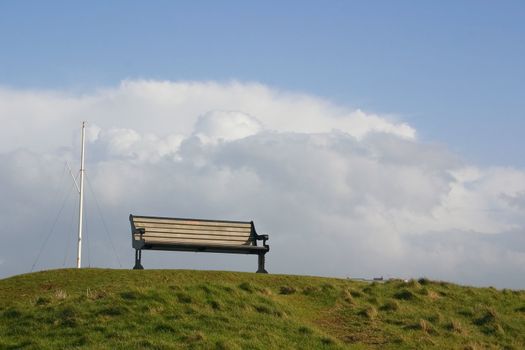 lonely bench sitting on the top of a hill
