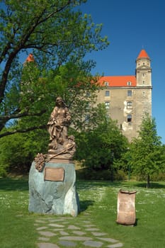 bratislava castle in background, woman sculpture in foreground, park
