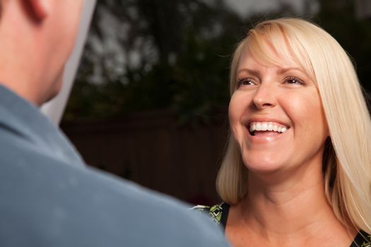 Wine Drinking Blonde Socializing with Man at an Evening Gathering.