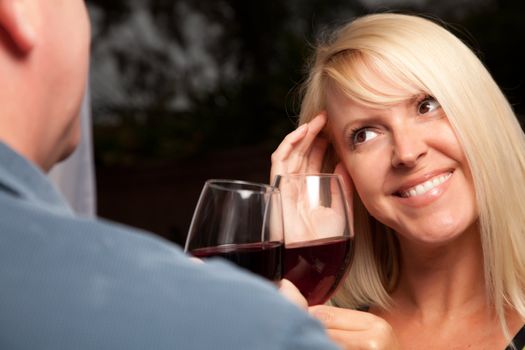 Wine Drinking Blonde Socializing with Man at an Evening Gathering.