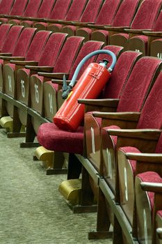 red fire extinguisher on red cinema seats, can be used insecurity subject