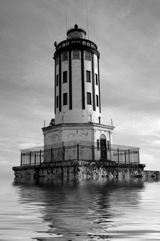 Very weathered lighthouse on the breakwater in black and white