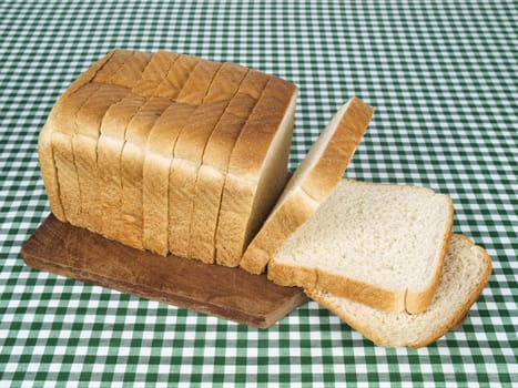 A sliced loaf of bread served on a wooden cutting board.