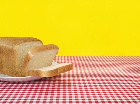 A loaf of bread sliced and served on the table.