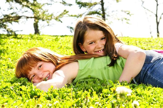 Portrait of happy girls playing on grass