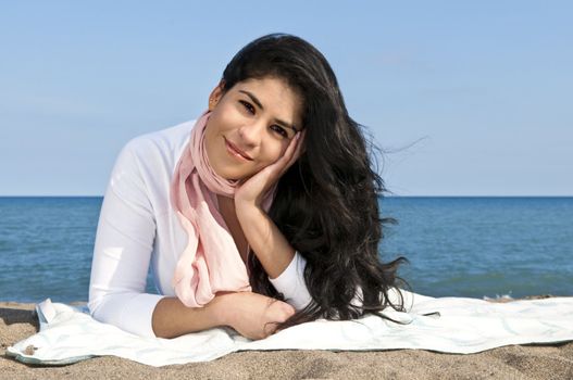 Portrait of beautiful smiling native american girl laying at beach