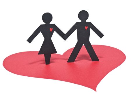 A couple of paper figures holding hands over a red paper heart. Isolated on white.