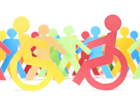 Two paper men on wheelchair. Multicolor paper crew on the background.