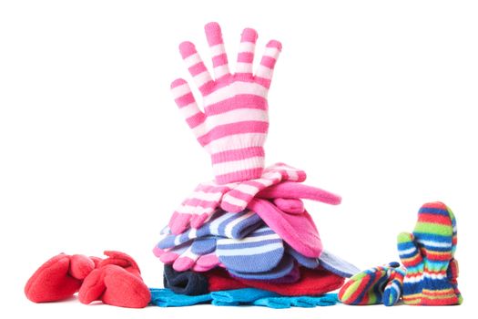 Pile of woollen garments and pink glove in greeting gesure at the top. Isolated over white