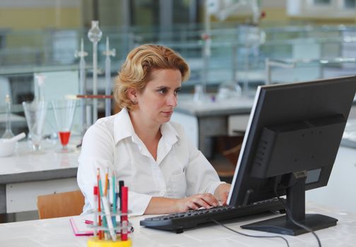 Female researcher working on a computer in a laboratory.
