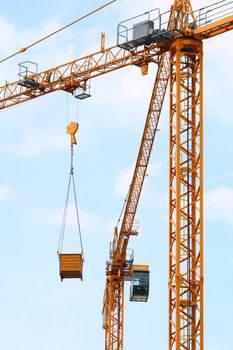 Cranes at the construction site with hooked crate