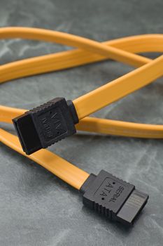 yellow Serial ATA cable with black connectors, marble like background