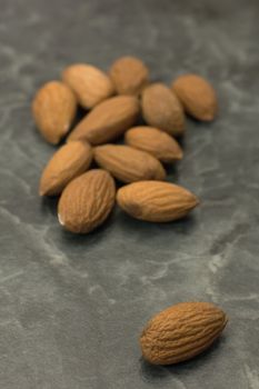several brown almnod nuts on dark marble background