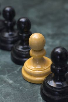 white chess man figure between black ones